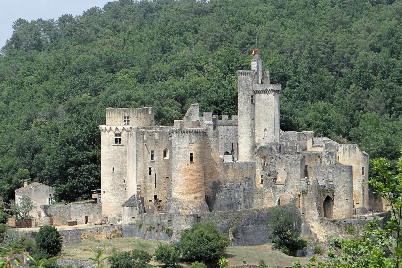 Il castello di Bonaguil e le sue torri sopra una valletta boscosa